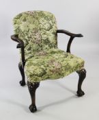 A George II style mahogany open armchair, with eagle head carved arms and over-stuffed serpentine