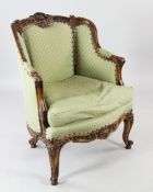 A Louis XV scroll carved walnut bergere chair, with green patterned upholstery, on scrolling