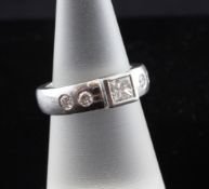 A platinum and princess cut diamond ring, with collet set central stone and each shoulder with two
