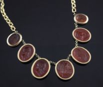 A gold and intaglio carnelian fringe necklace, set with seven oval intaglios carved with the heads