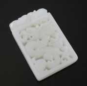A Chinese white jade plaque, carved with a dragon amid scrolls, 5.5cm.