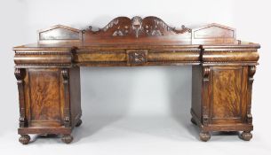 A large William IV mahogany inverted breakfront pedestal sideboard with scroll carved gallery back