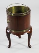 A George III style circular mahogany jardiniere stand, with brass liner and swing handle, with