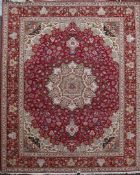 A Tabriz part silk carpet, with central foliate medallion in a field of scrolling foliage, on a