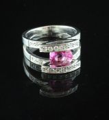 A 14ct white gold, pink sapphire and diamond set dress ring, with oval cut stone set in between