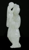 A Chinese greyish white jade group of a woman holding a monkey, 18th / 19th century, the woman