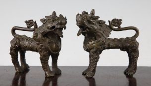 A pair of Tibetan bronze temple lion-dogs, 19th century, each with raised scrolling decoration, 12 -