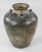 A large South East Asian pottery Martavan jar, with a black / brown glaze and three lug handles to