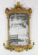 An 18th century carved giltwood wall mirror, with distressed rectangular mirror plate glass,