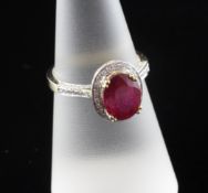 A 14ct white gold ruby and diamond dress ring, with oval cut ruby and diamond set border and