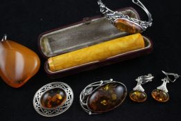 Four items of silver mounted amber jewellery, including bangle and ear clips, together with a larger