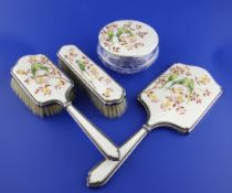 A 1950`s four piece silver and enamel dressing table set by Garrard & Co Ltd, comprising a mirror,