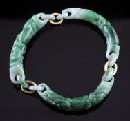 A carved jadeite bracelet, with three curved sections decorated with fruit and flowers.
