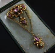 A Victorian gold, pink topaz and green gem set drop brooch, the repousse scroll setting with drop