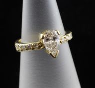 An 18ct gold and pear shaped diamond ring, with round cut diamond set shoulders, size K.