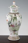 A Chinese famille rose baluster vase and cover, 19th century, painted to two medallions with figures