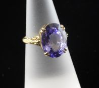 An 18ct gold and solitaire sapphire dress ring, with oval cut stone and carved shoulders, size M.
