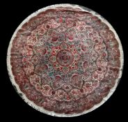 A Tabriz silk circular rug, with cusped boder and decorated with central foliate medallion and