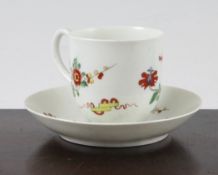 A Worcester polychrome cup and saucer, c.1770, painted with brightly coloured flowers and