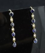 A pair of gold, sapphire and diamond drop earrings, each set with seven round, oval or pear shaped