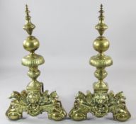 A pair of large brass and iron fire dogs, Dutch c.1700, of globular and vasiform, the support in the