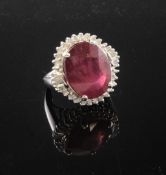 A 14ct white gold oval cut ruby, round and baguette cut diamond cluster ring, size G.