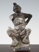 A Chinese painted stone figure of a seated foreigner, Tang dynasty, 26cm., damages