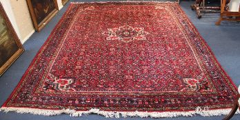 A Hamadan carpet, with central foliate medallion in a tightly packed field of geometric floral