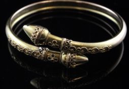 A Victorian gold bangle, with cannetile work decoration and conical terminals, in gilt tooled