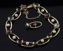An Edwardian 15ct gold, seed pearl and multi gem set oval link bracelet, set with nine round cut