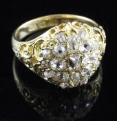 A Victorian 18ct gold and diamond cluster ring, with pierced and carved shoulders and set with