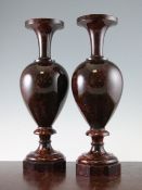 A pair of Victorian red cornish serpentine marble vases, each on an octagonal base, 17.25in.