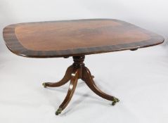 A rectangular rosewood crossbanded breakfast table, with turned central column and downswept legs,