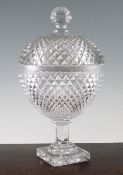 A large Regency cut glass oviform jar and cover, c.1810, with diamond cut bands all over, on an