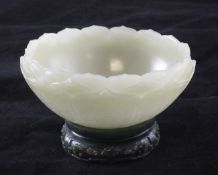 A Chinese pale celadon jade `lotus` bowl and spinach green jade stand, the lotus petalled bowl with