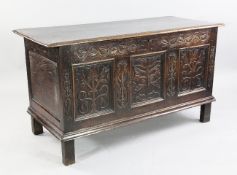 A carved oak coffer, the triple front decorated with stylised flowers and leaves and with the