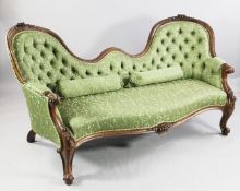 A Victorian carved walnut double scroll back settee, with green patterned button upholstery, scroll