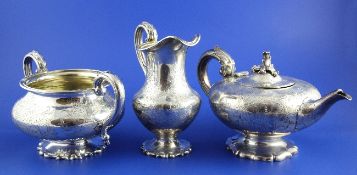 A Victorian silver three piece tea set, of squat circular form, with engraved foliate decoration,