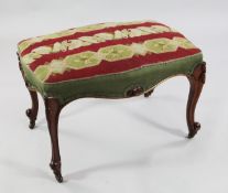 A Victorian mahogany serpentine foot stool, with needlepoint upholstered top, on carved cabriole