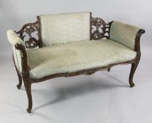 A Louis XV style walnut framed settee, with distressed pale green striped fabric, with pierced