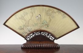 A Chinese gilt ground paper fan leaf, with rosewood stand, Qing dynasty, the fan decorated with two