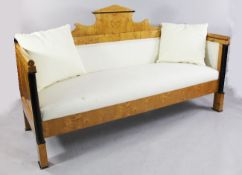 A 19th century Biedermeier settee, upholstered in a pale cream fabric, with shaped architectural