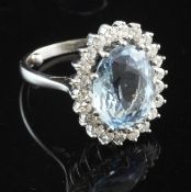 An 18ct white gold, aquamarine and diamond cluster ring, of oval form, size G.
