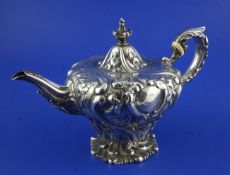 A William IV silver melon-shaped teapot, decorated with flowers and foliage and with leaf-wrapped