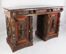 A large Anglo Burmese teak pedestal sideboard, carved throughout with figures and foliate scrolls,