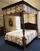 A mahogany four poster bed, with tapering fluted end posts, together with floral red and cream
