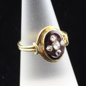 A late Victorian gold, garnet and diamond ring, of oval form, set with rose cut diamonds, size O.
