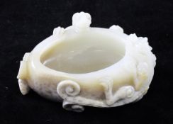 A Chinese Hetian `chicken bone` jade brushwasher, 20th century, of oval form carved in high relief