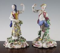 A pair of Bow figures, c.1760, modelled as a gentleman and lady on floral encrusted scrollwork