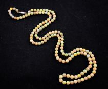 A single strand graduated white opal bead necklace, with gold cylindrical clasp, 29in.